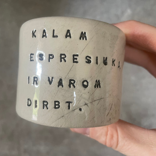 Du maži espresso puodeliai su tekstu apie darbą