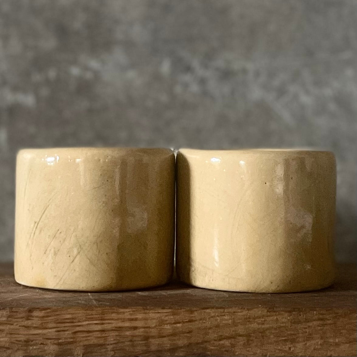 A pair of small mugs with words in Lithuanian