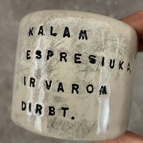 A set of small mugs with words in Lithuanian
