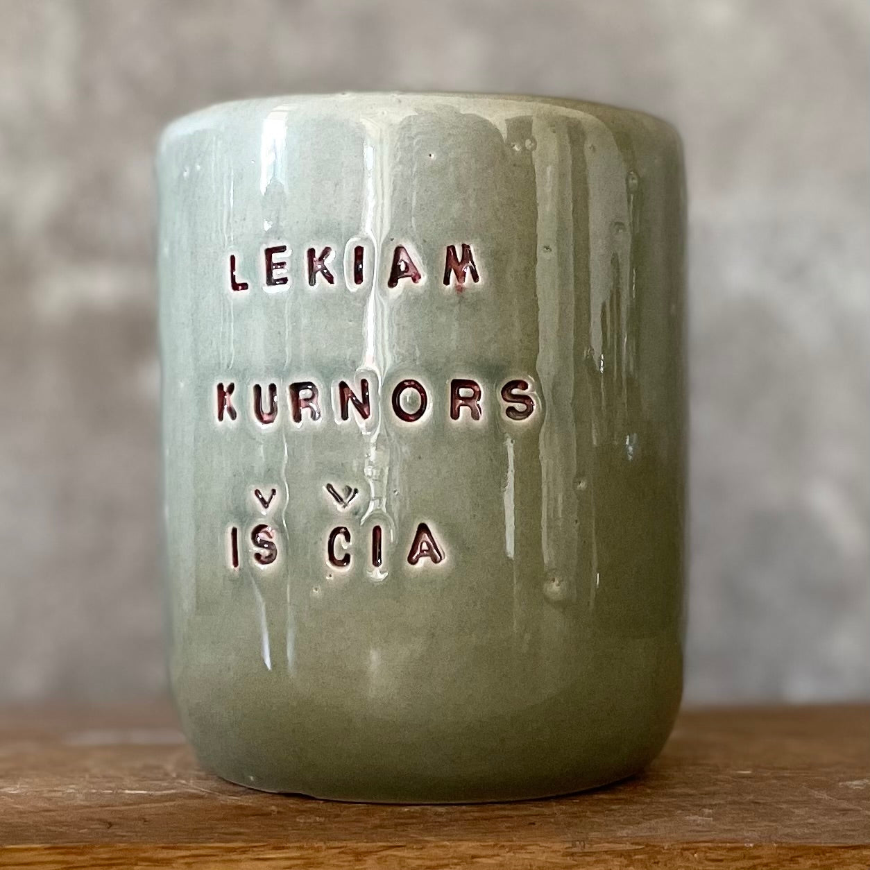 Green mug with words in Lithuanian