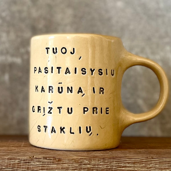 Geltonas puodelis su užrašu