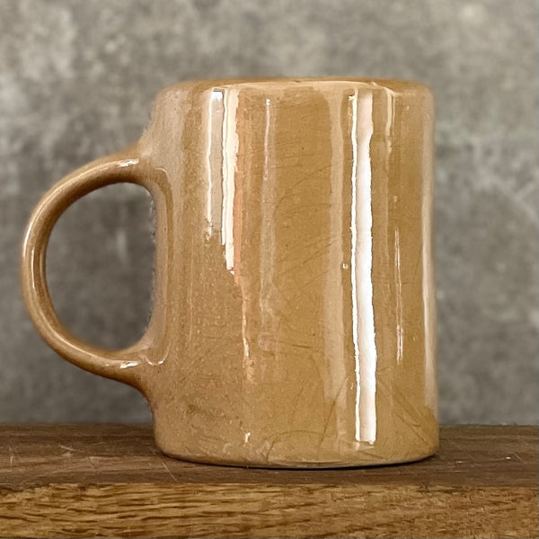 Gelsvai rusvas puodelis su linksmu užrašu