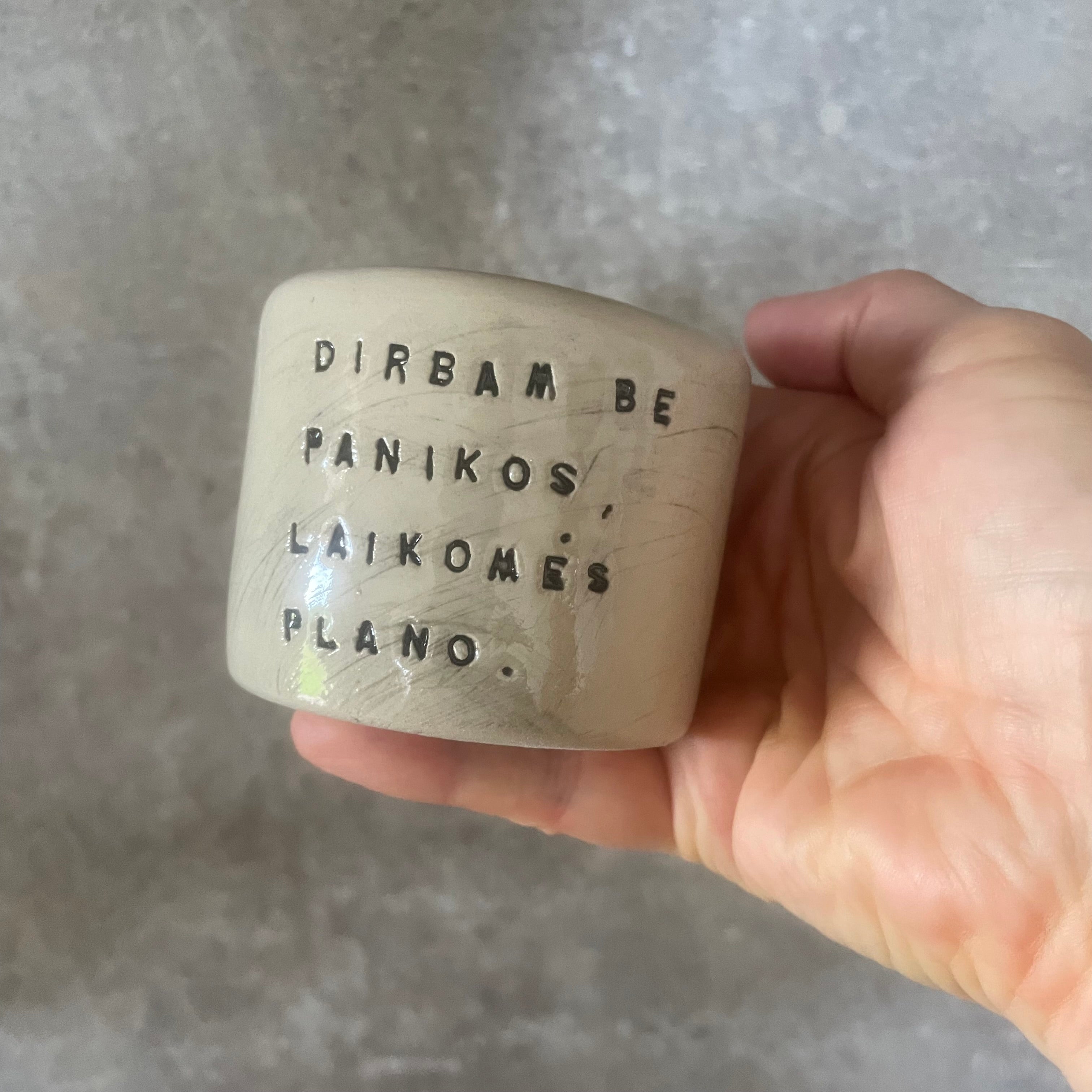 A set of small mugs with words in Lithuanian