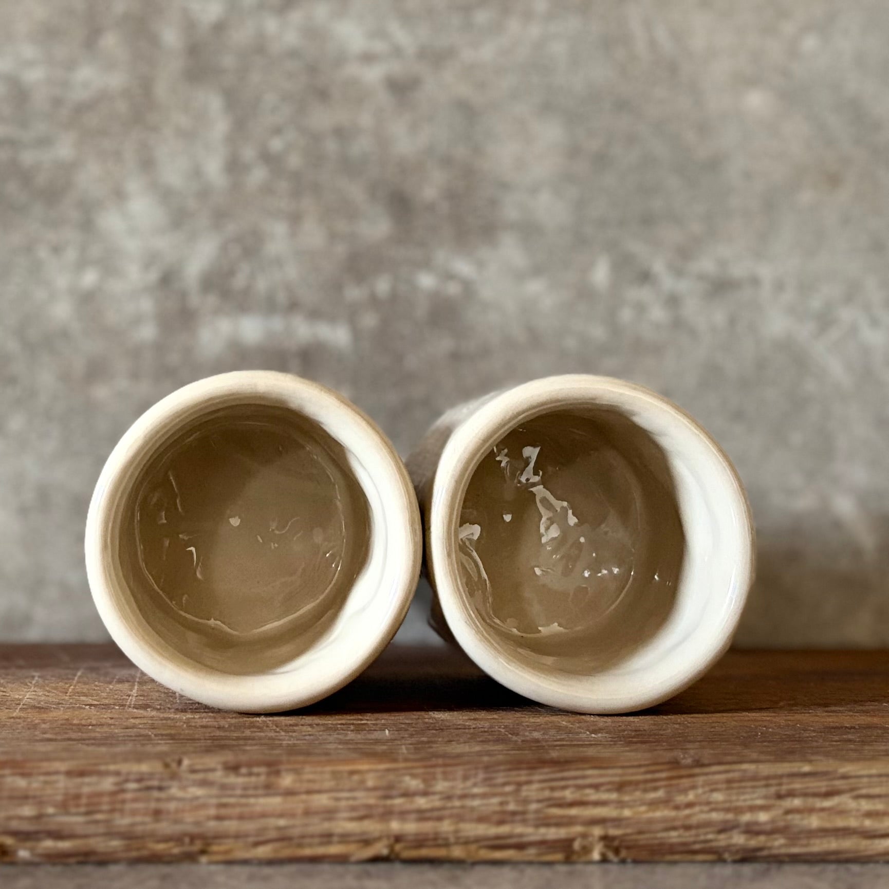 Du maži espresso puodeliai su tekstu apie darbą