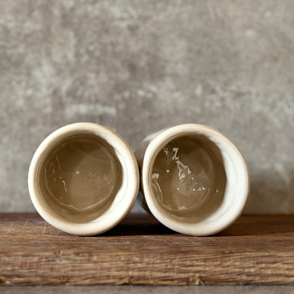 Du maži espresso puodeliai su tekstu apie darbą