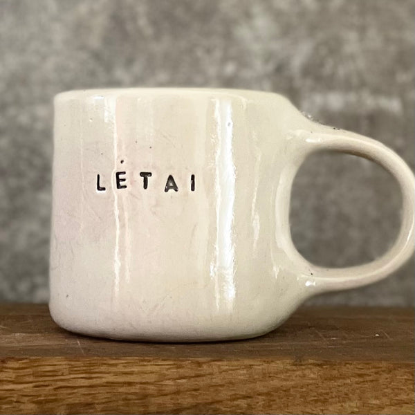 Pale pink ceramic mug with word LĖTAI