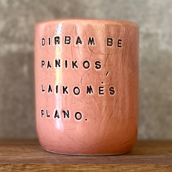 Raudonas didelis puodelis be rankenos su užrašu