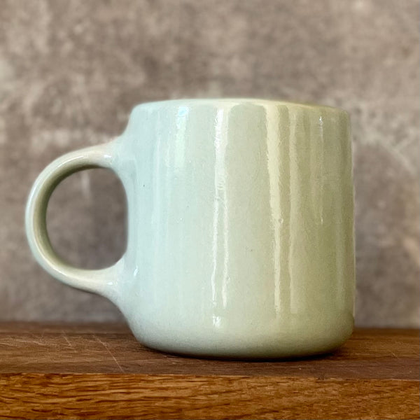 Greenish mug with words about work