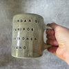Green ceramic mug with words about work