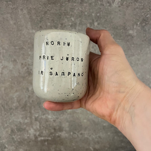Small speckled mug without handle with text in Lithuanian