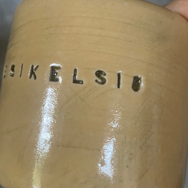 A pair of small mugs with words in Lithuanian