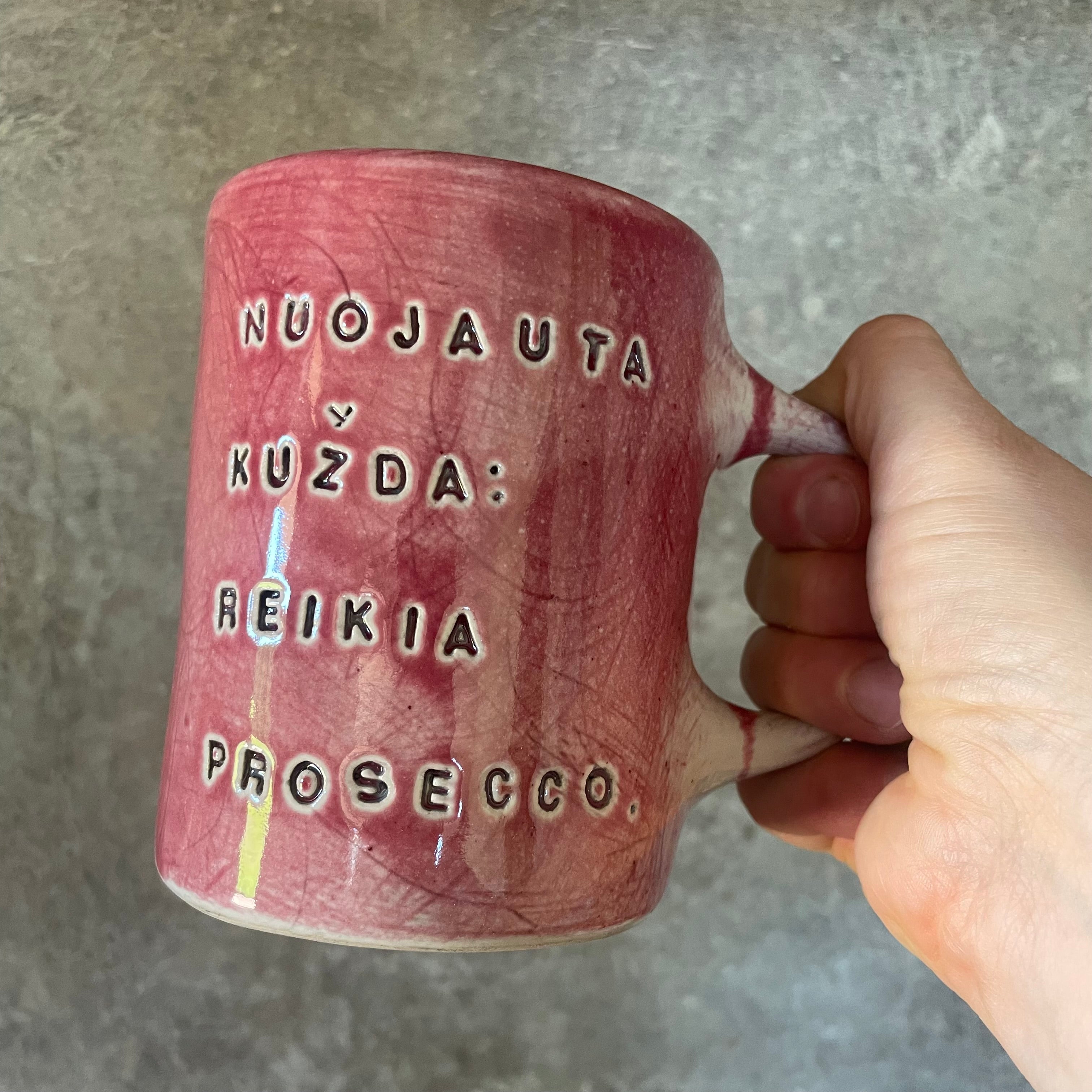 Puodelis su linksmu užrašu apie prosecco