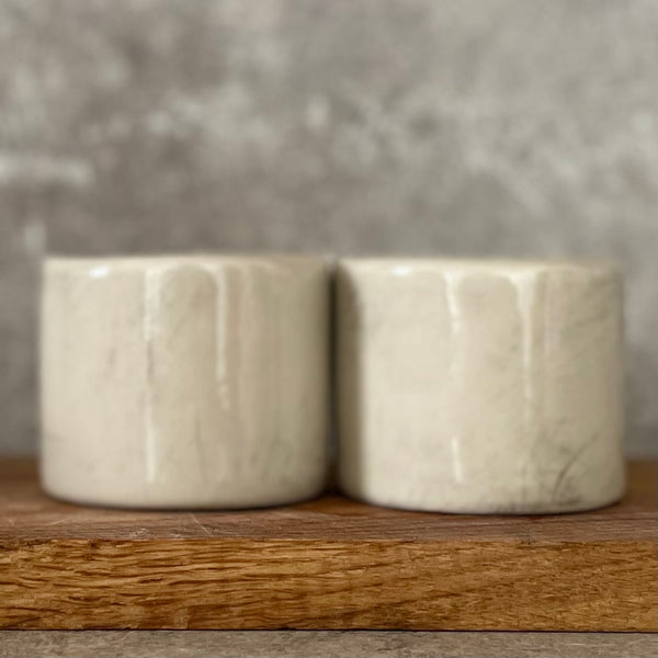 Du maži espresso puodeliai su tekstu apie darbą