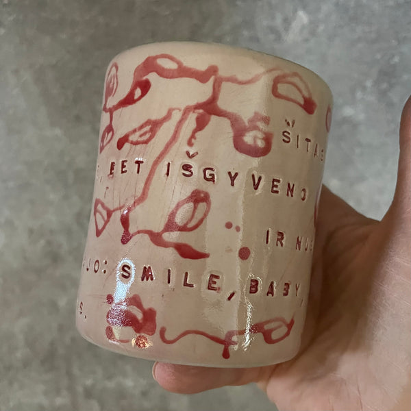 Rausvas gėlėtas puodelis su ilgu tekstu