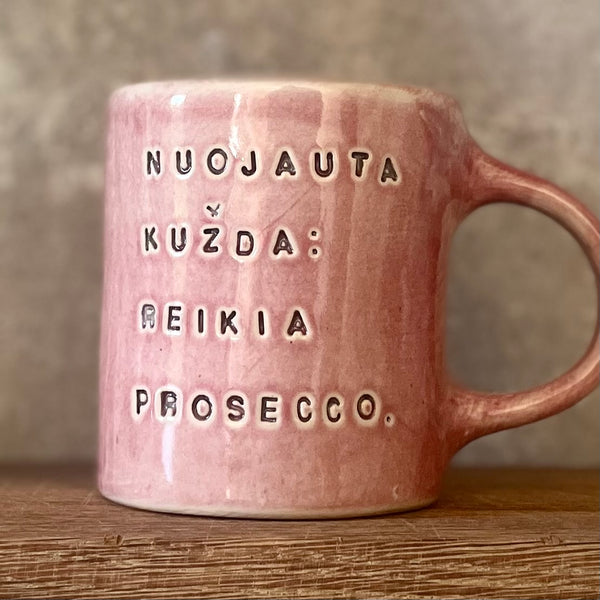 Puodelis su linksmu užrašu apie prosecco