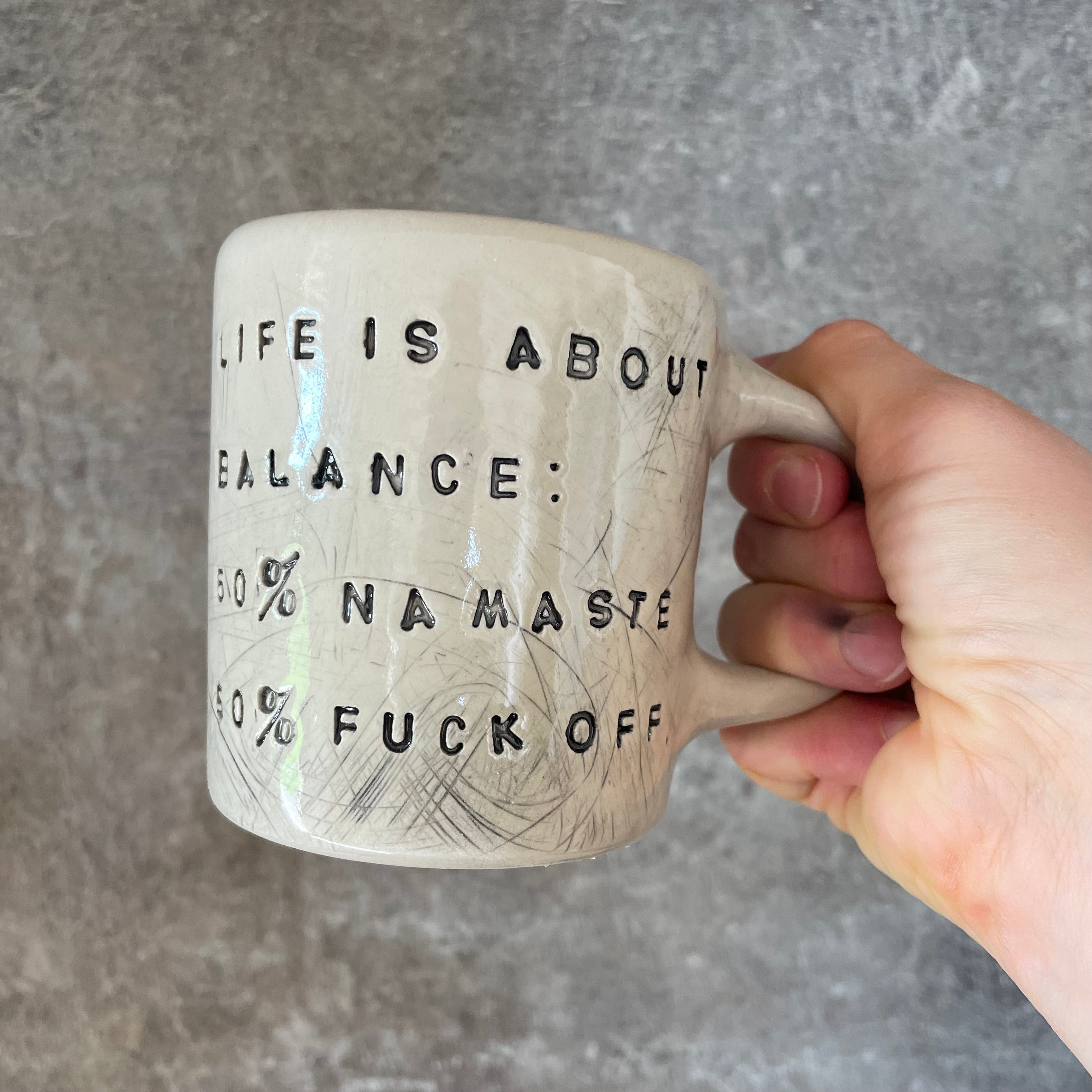 Ceramic mug with saying about balance with handle
