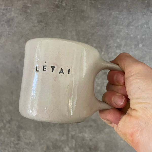 Pale pink ceramic mug with word LĖTAI