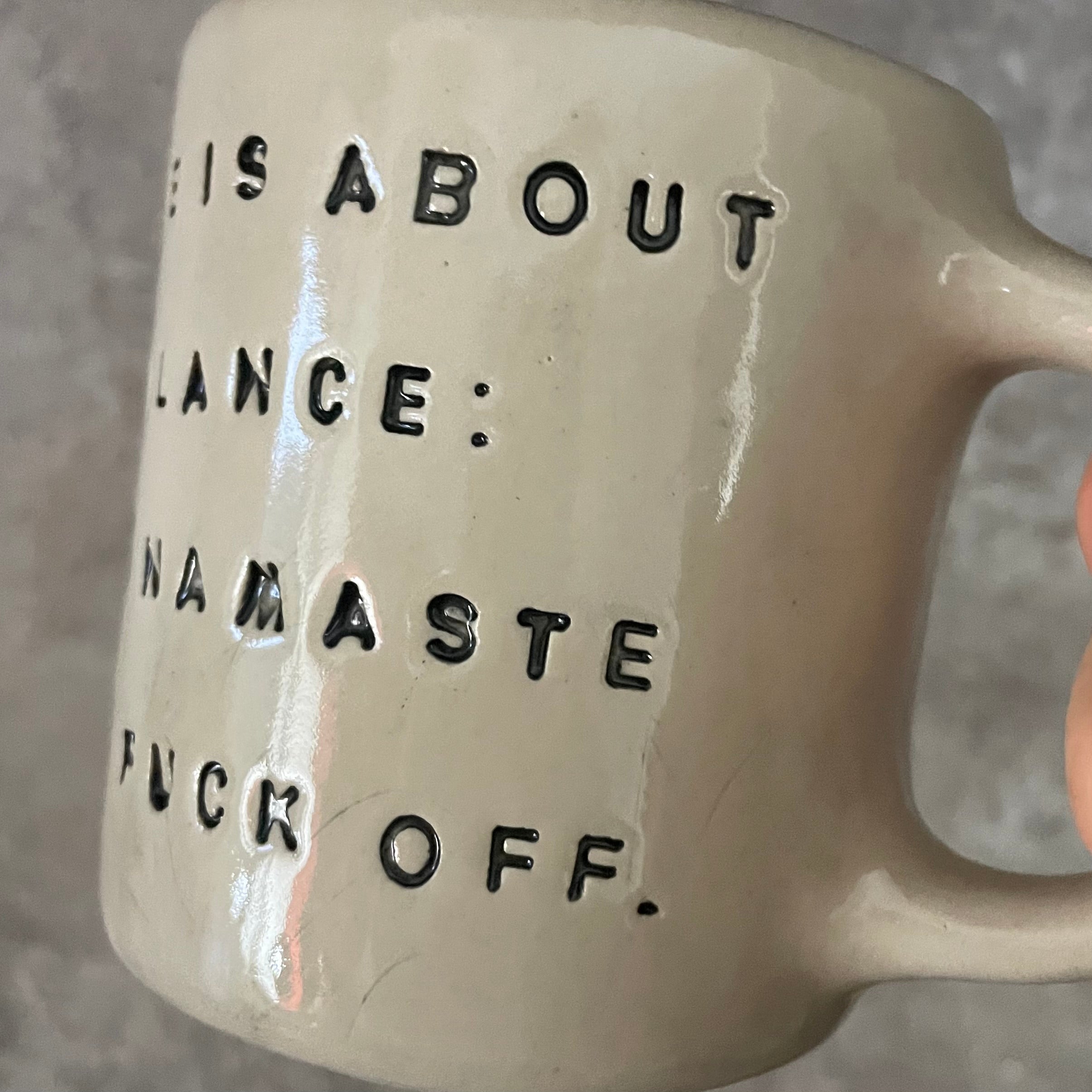 Puodelis su užrašu apie balansą su ąsele