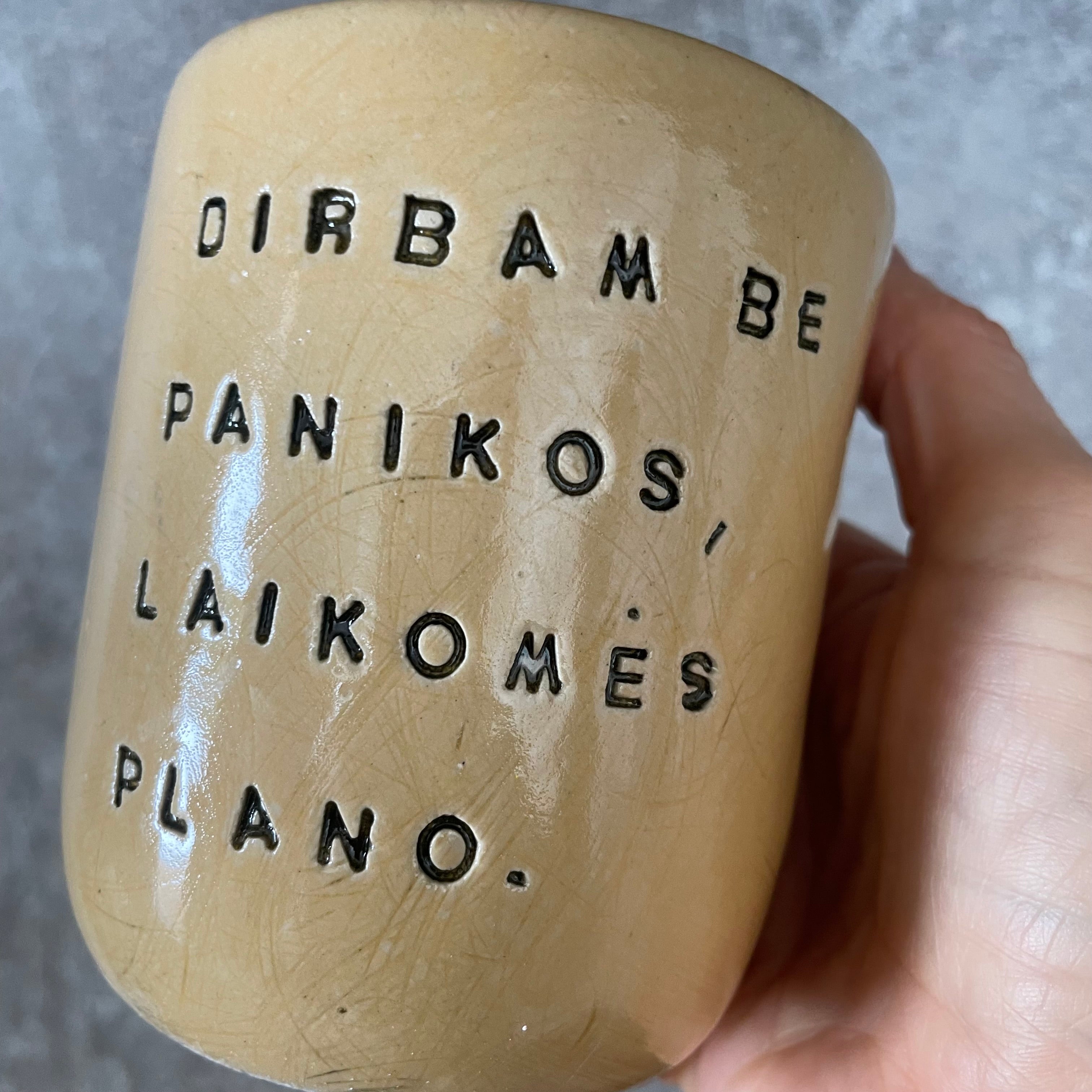 Geltonas didelis puodelis be rankenos su užrašu