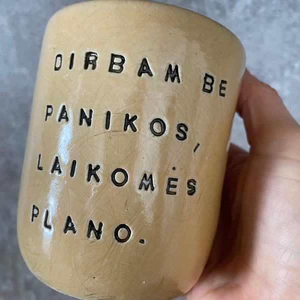Geltonas didelis puodelis be rankenos su užrašu