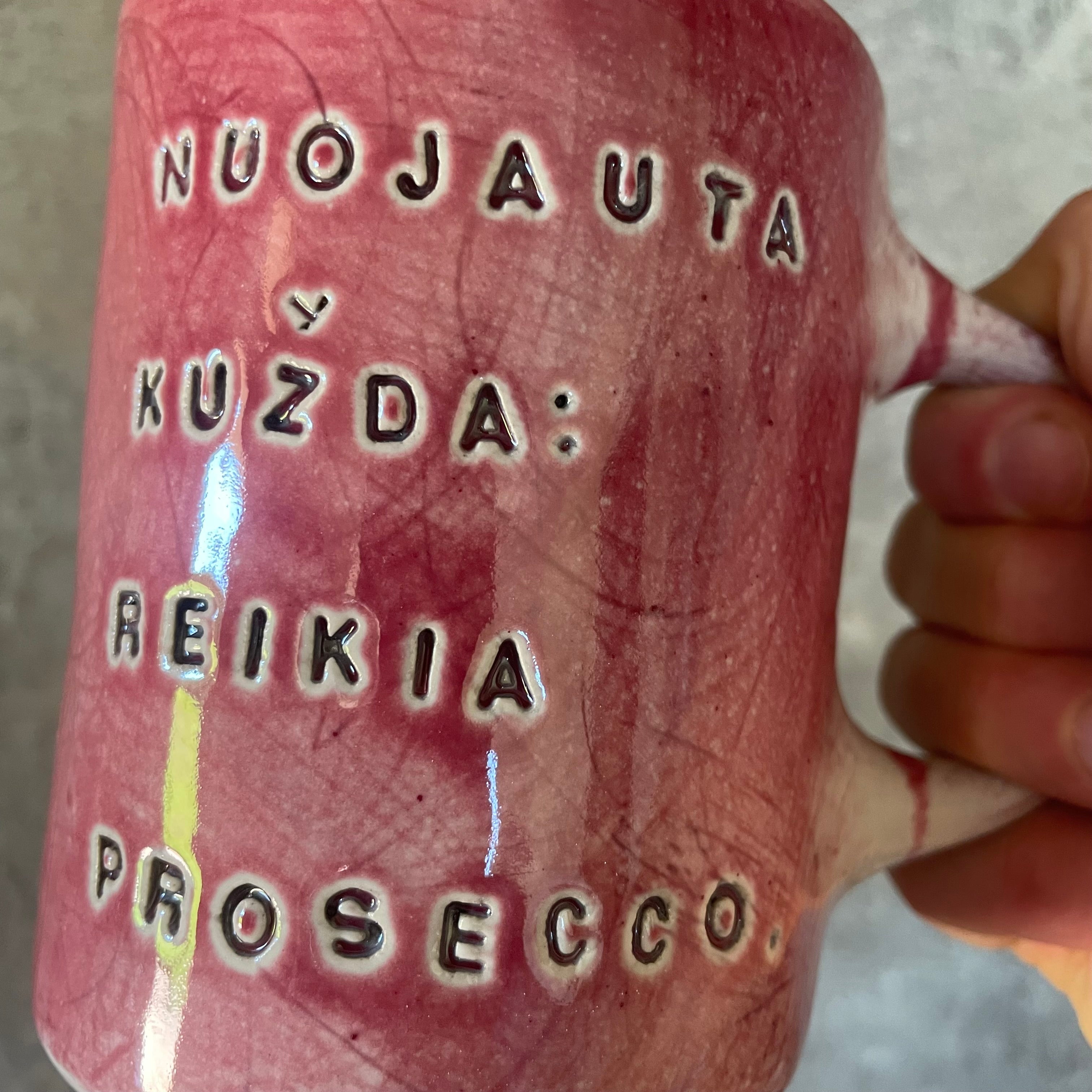 Puodelis su linksmu užrašu apie prosecco