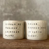 A set of small mugs with words in Lithuanian