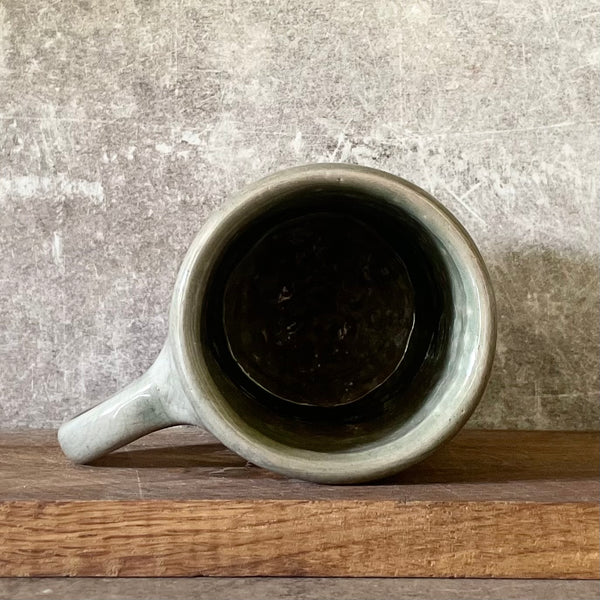 Green ceramic mug with words about work
