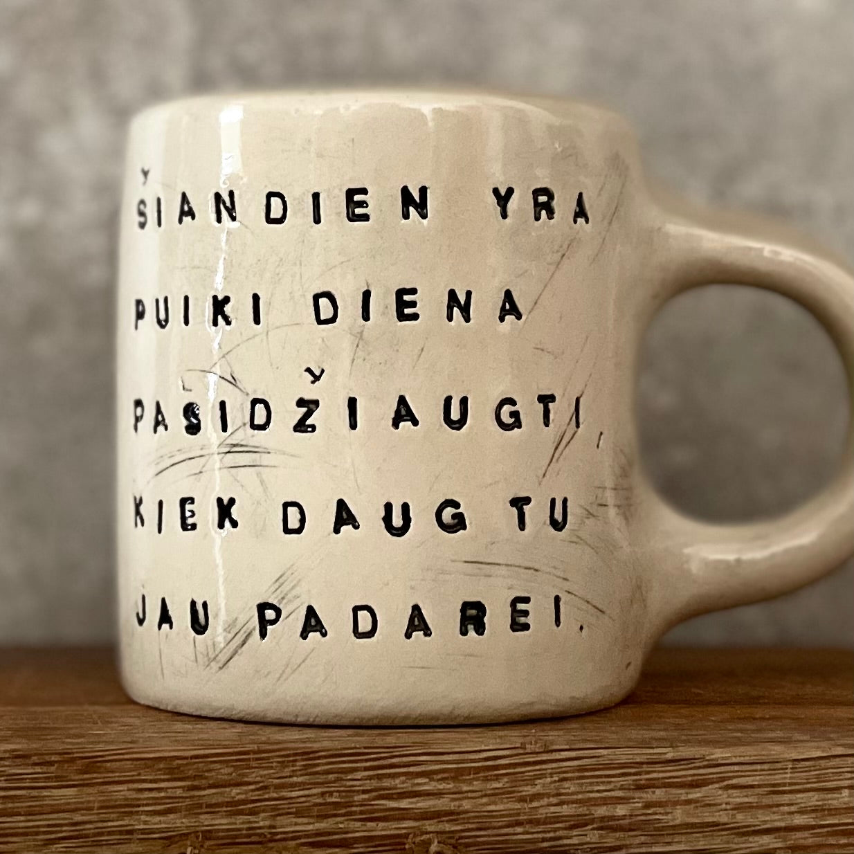 Puodelis su optimistiniu užrašu