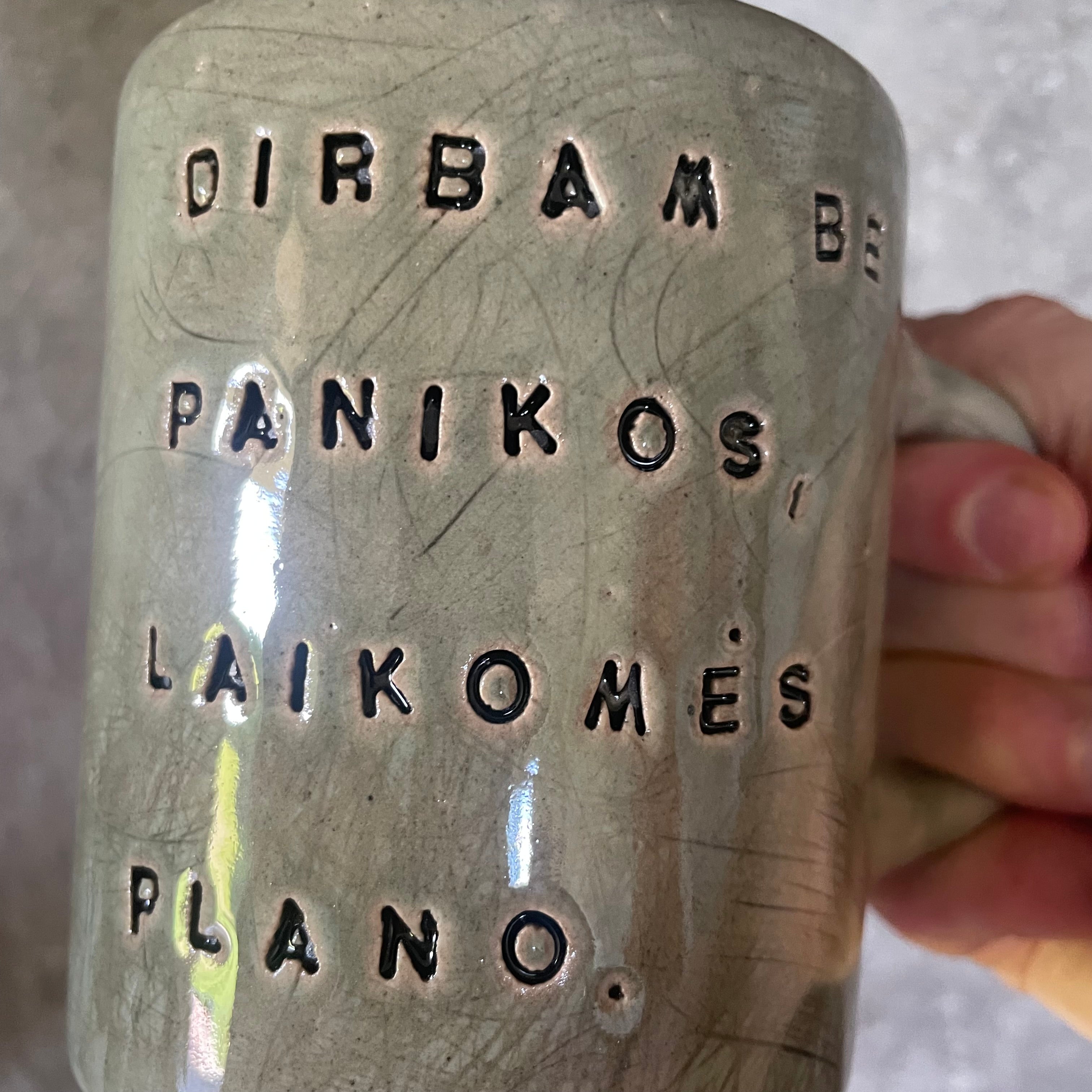 Green ceramic mug with words about work