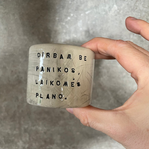 A set of small mugs with words in Lithuanian