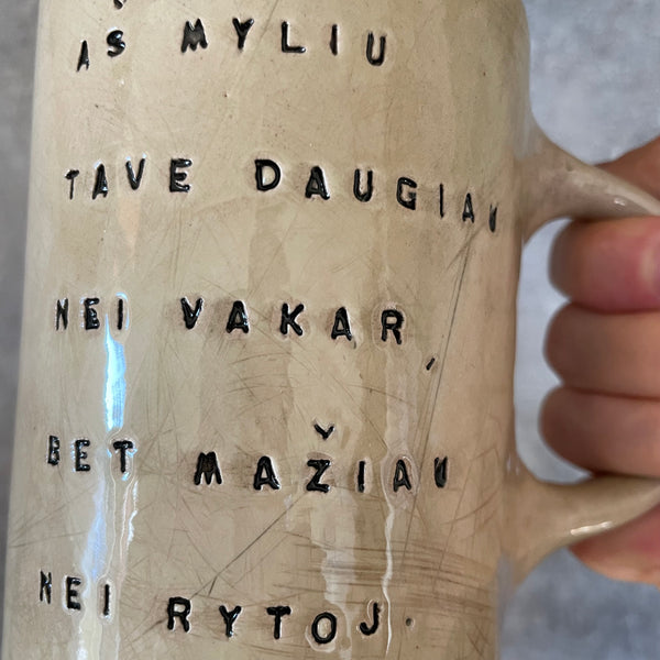 Rusvas puodelis su užrašu apie meilę