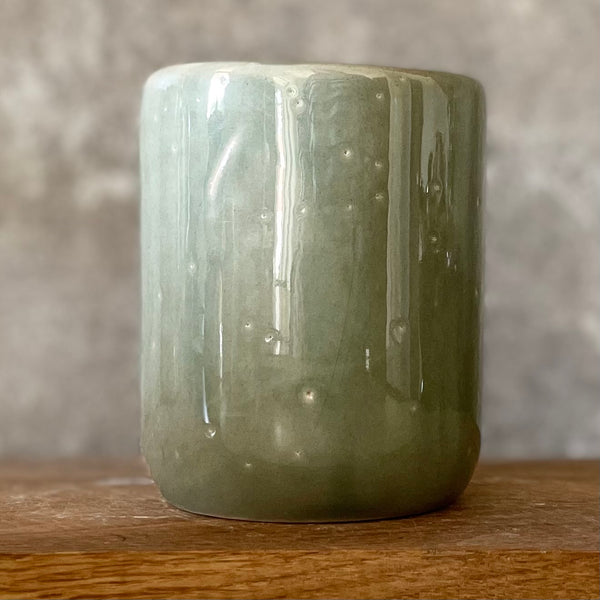Green mug with words in Lithuanian