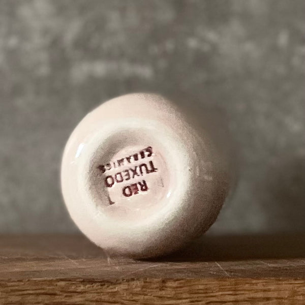 Small pink mug without handle with text in Lithuanian