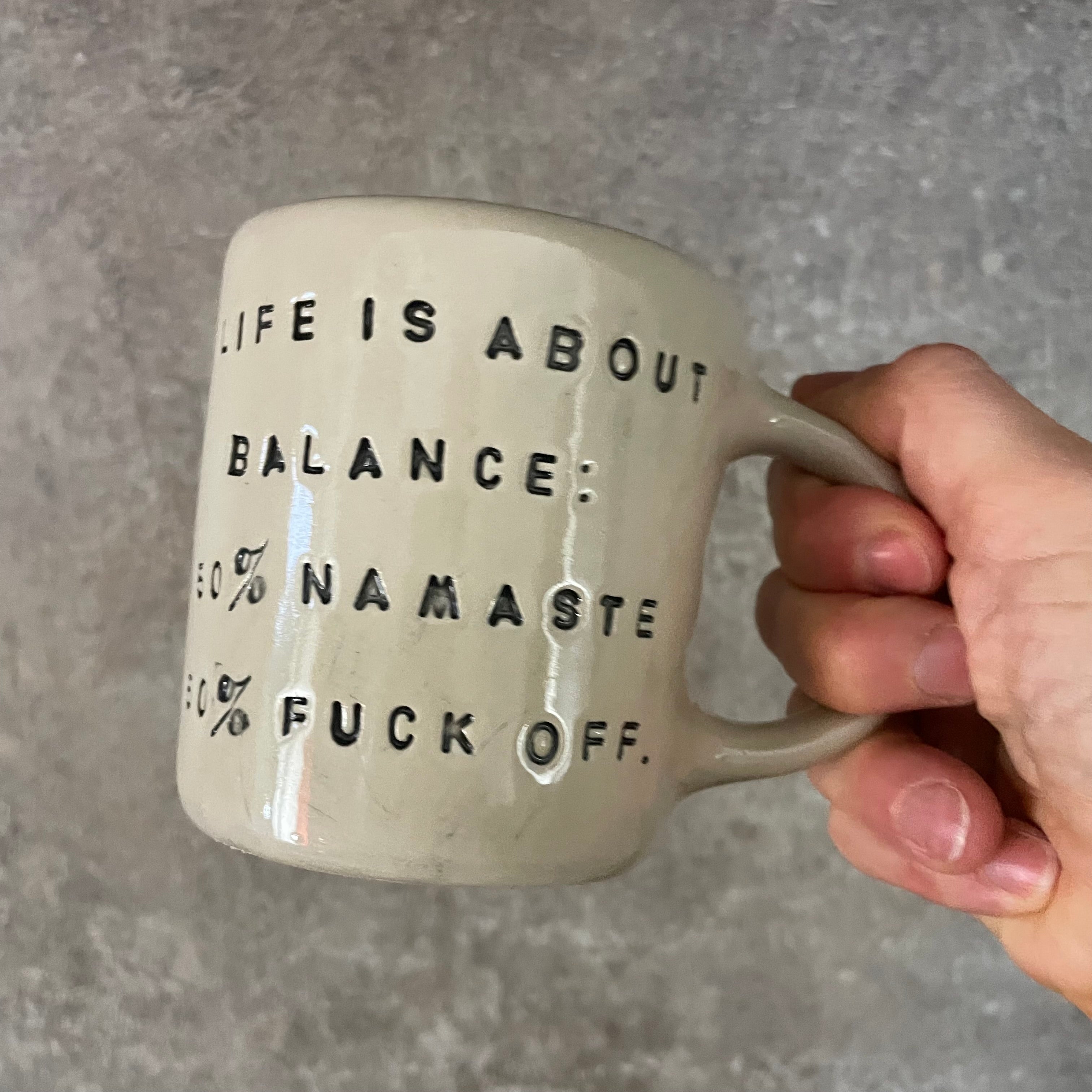 Puodelis su užrašu apie balansą su ąsele