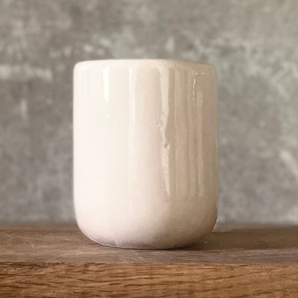 Small pink mug without handle with text in Lithuanian