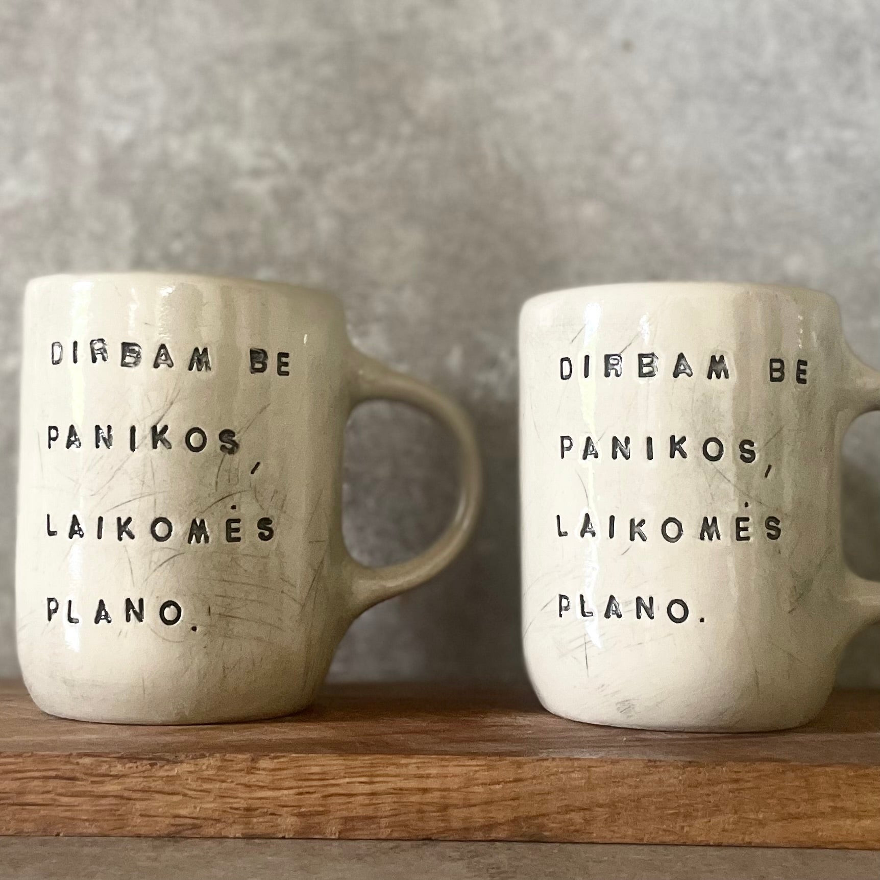 Two big ceramic mugs with words about work