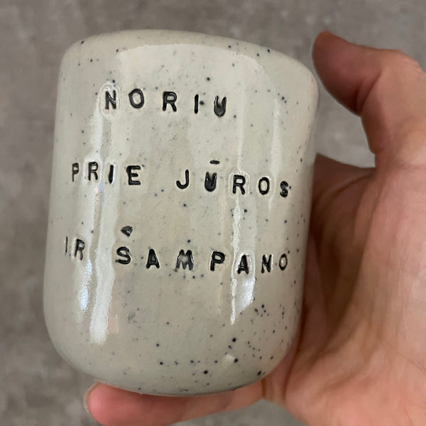 Small speckled mug without handle with text in Lithuanian