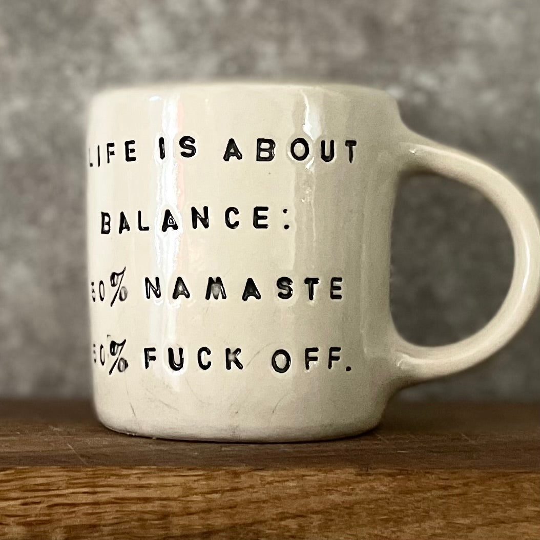 Puodelis su užrašu apie balansą su ąsele