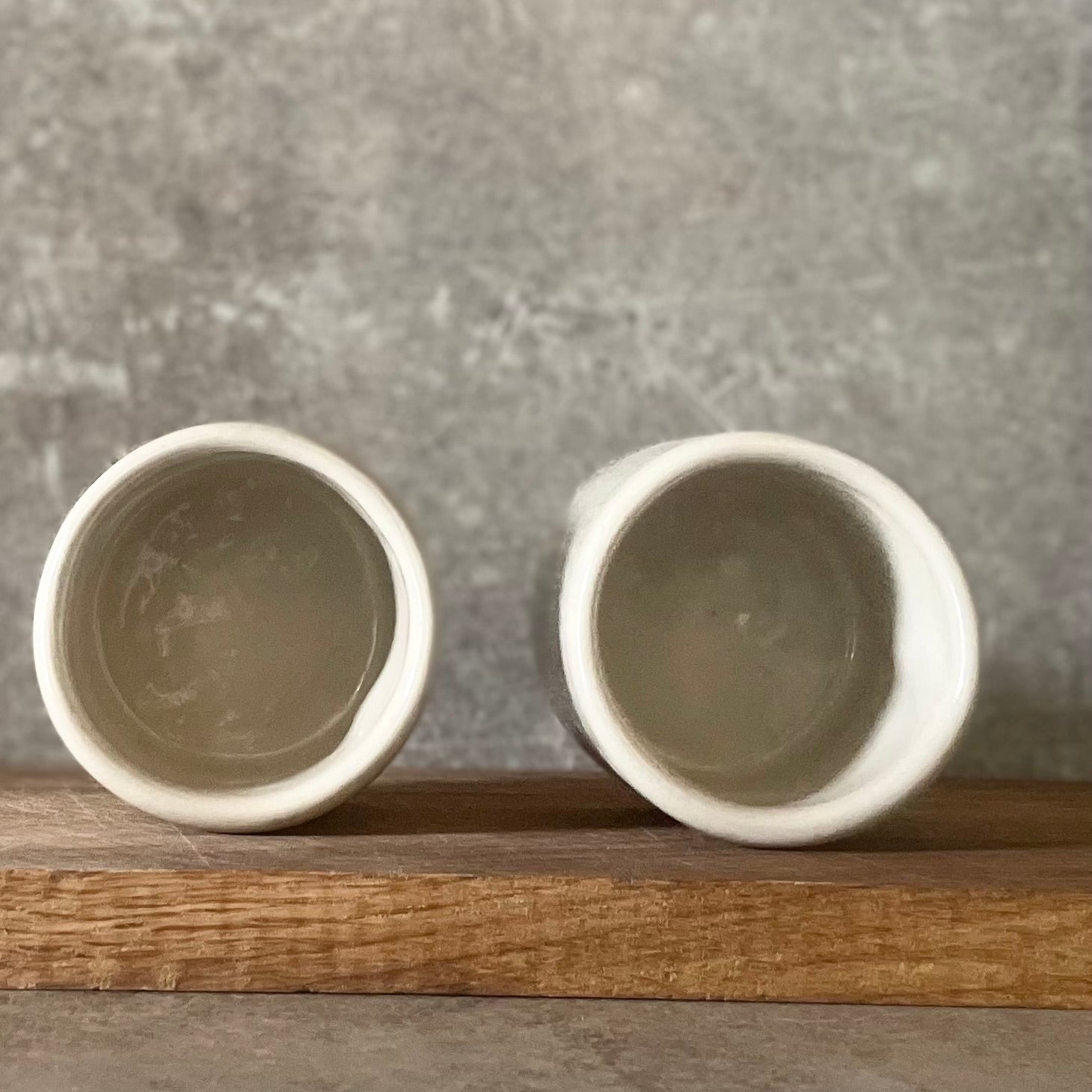 Du maži espresso puodeliai su tekstu apie darbą