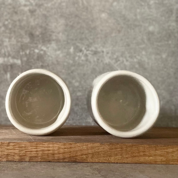 Du maži espresso puodeliai su tekstu apie darbą