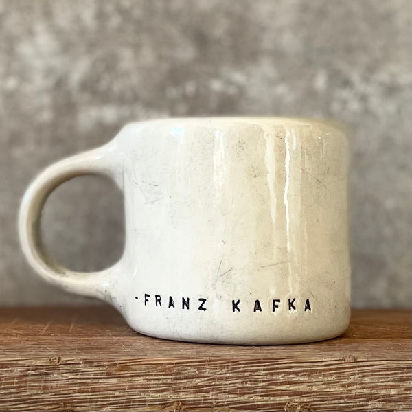 Keramikinis puodelis su Kafkos citata