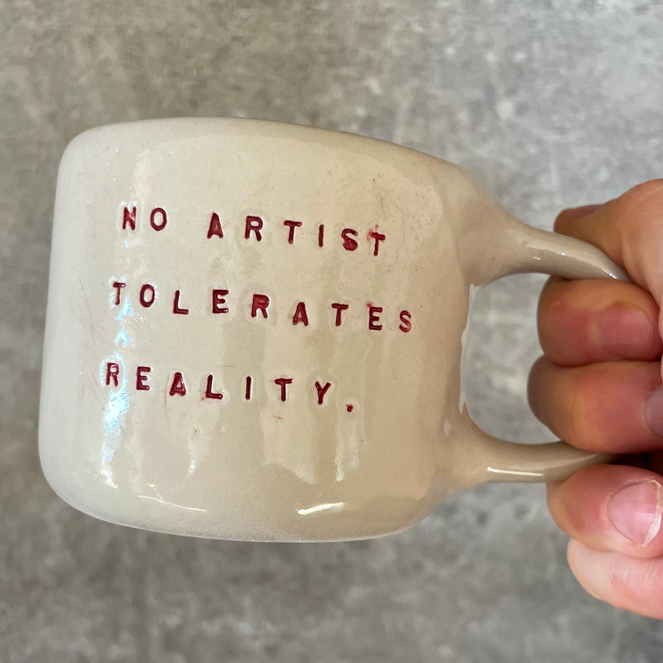 Puodelis su citata “No artist tolerates reality