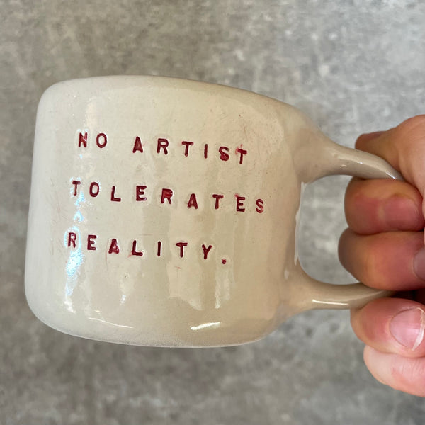 Puodelis su citata “No artist tolerates reality"