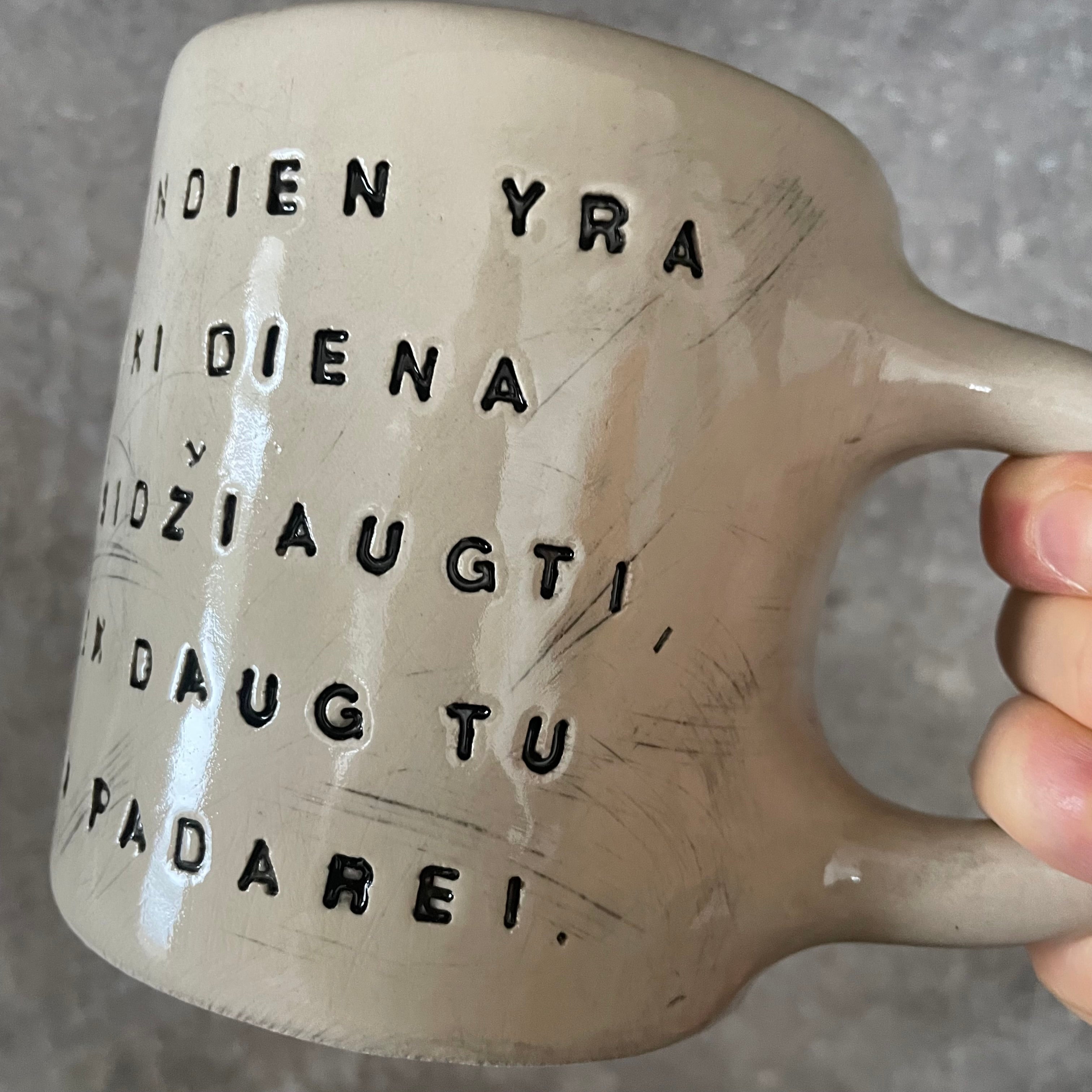 Puodelis su optimistiniu užrašu
