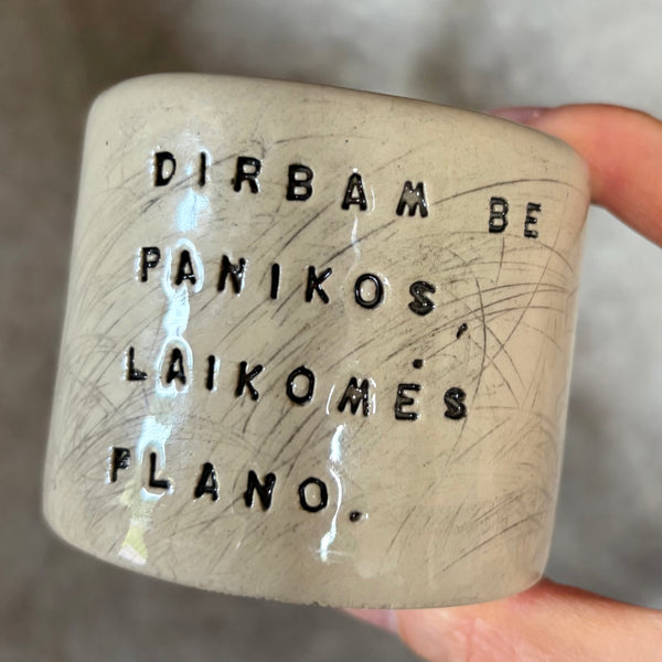 Du maži espresso puodeliai su tekstu apie darbą