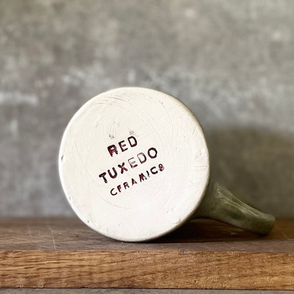 Green ceramic mug with words about work