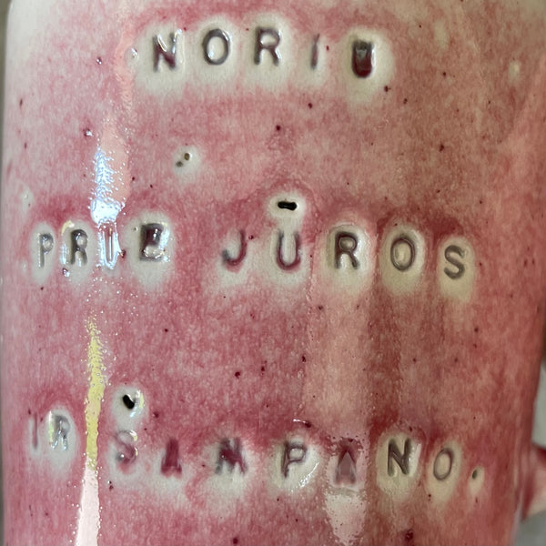 Puodelis su užrašu apie šampaną
