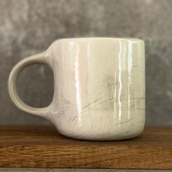 White irregular mug with words about work