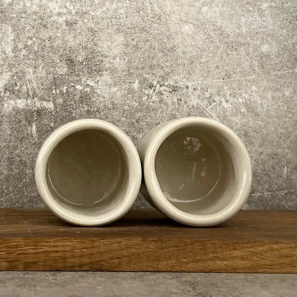 A set of small mugs with words in Lithuanian