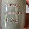 Green mug with words in Lithuanian